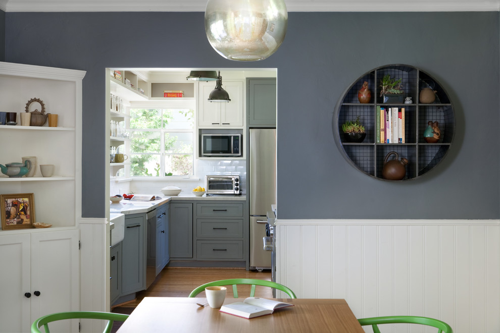 На фото: большая кухня-столовая в стиле неоклассика (современная классика) с синими стенами и паркетным полом среднего тона с