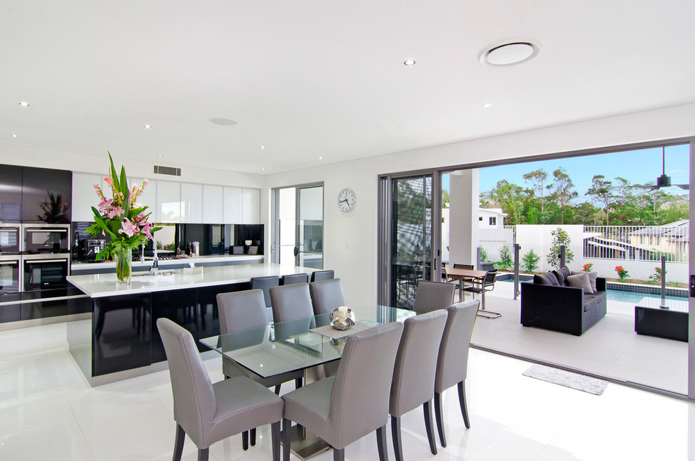 Contemporary open plan dining room in Gold Coast - Tweed with white floors and feature lighting.