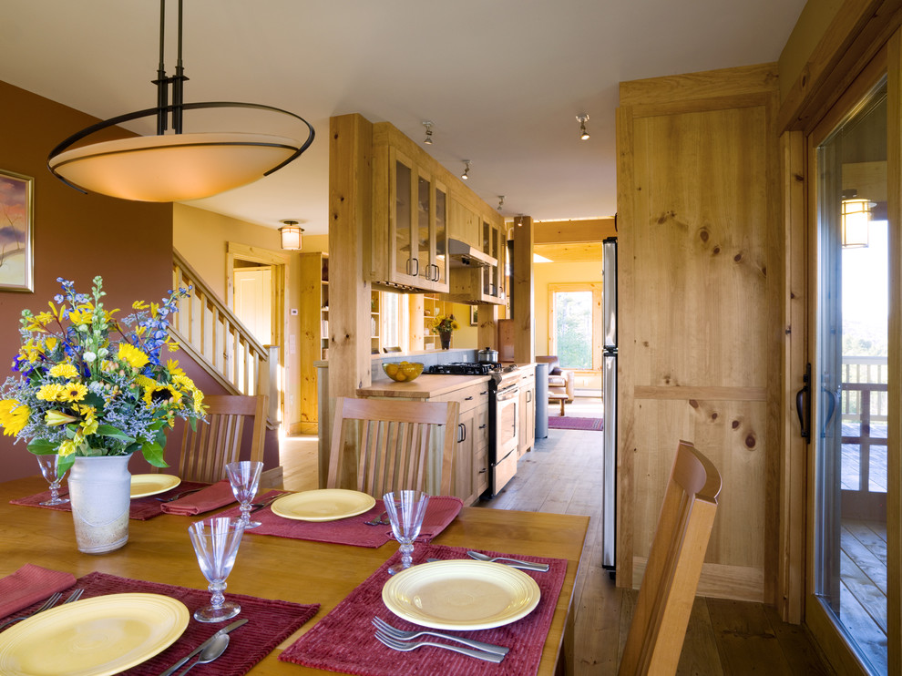 Cette image montre une salle à manger chalet avec un mur beige et un sol en bois brun.