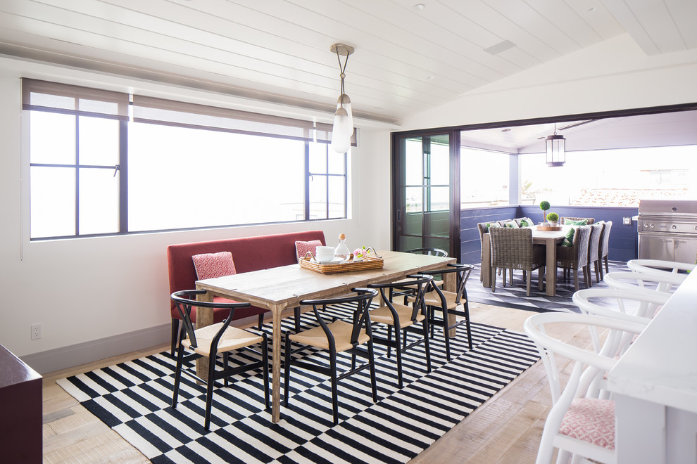 Ispirazione per una sala da pranzo aperta verso la cucina stile marino con pareti bianche, parquet chiaro e pavimento beige