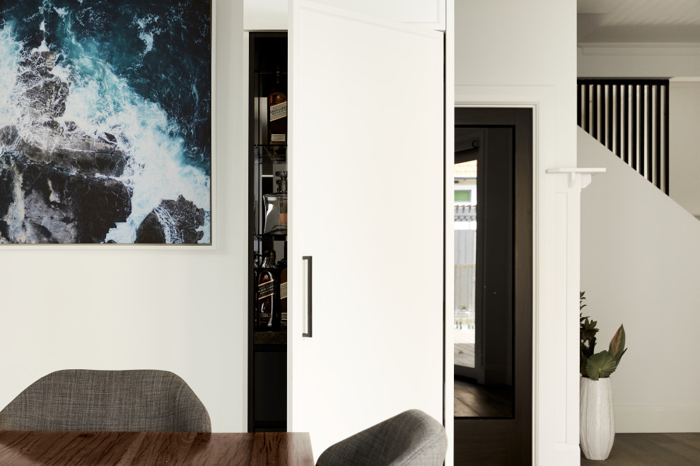 Esempio di una piccola sala da pranzo aperta verso la cucina minimalista con pareti bianche, parquet scuro e pavimento marrone