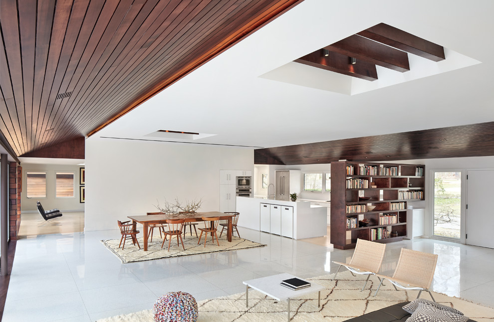 This is an example of a scandinavian open plan dining room in New York with white walls and no fireplace.