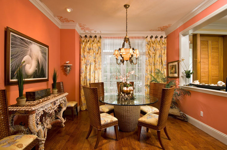 This is an example of a medium sized classic enclosed dining room in Miami with orange walls, medium hardwood flooring, no fireplace and brown floors.