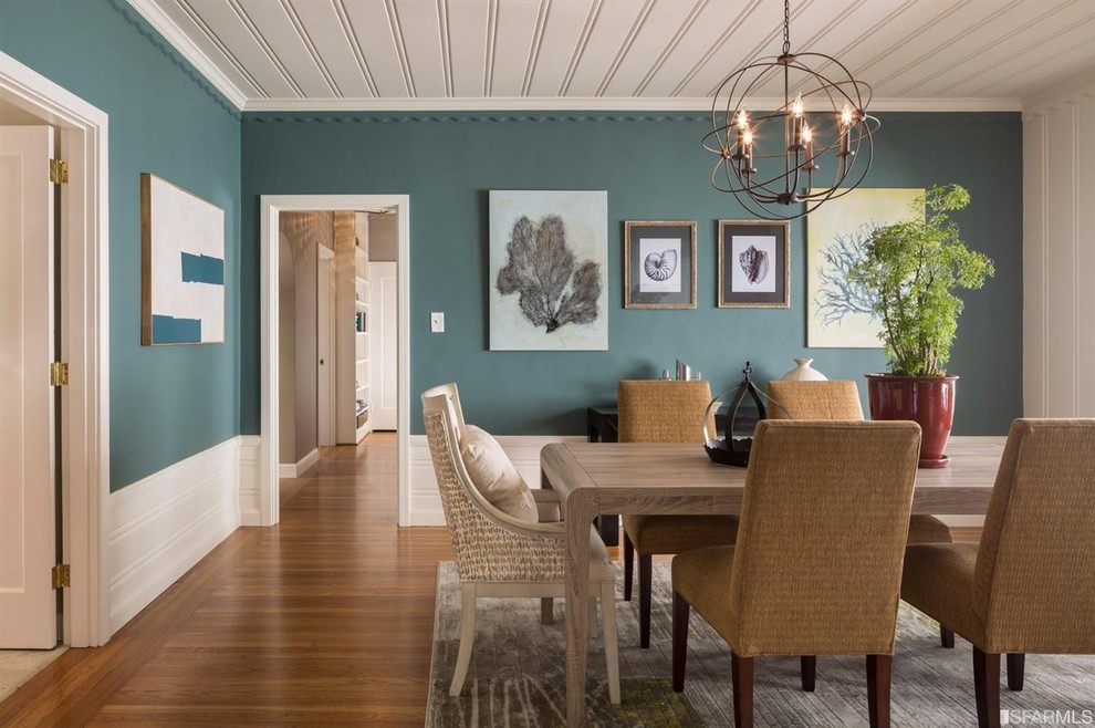 Inspiration pour une grande salle à manger rustique fermée avec un mur bleu, un sol en bois brun et aucune cheminée.