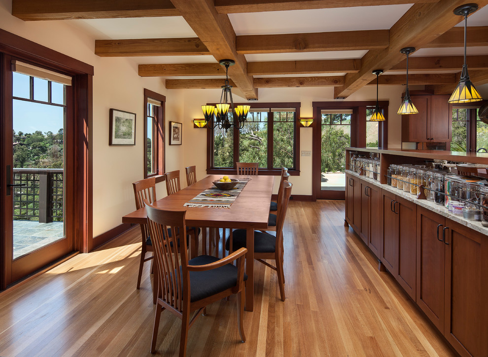 Exemple d'une salle à manger craftsman avec un mur beige et un sol en bois brun.