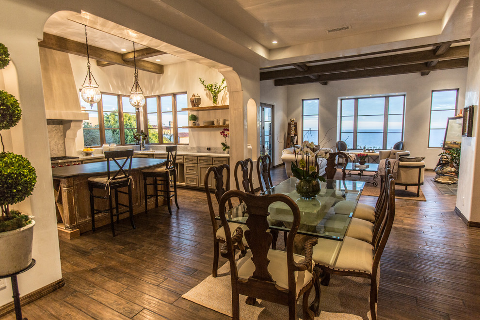 Mittelgroße Mediterrane Wohnküche ohne Kamin mit weißer Wandfarbe, braunem Holzboden und braunem Boden in Santa Barbara