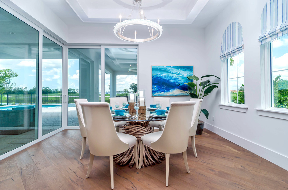 This is an example of an expansive contemporary kitchen/dining room in Miami with white walls, medium hardwood flooring and no fireplace.