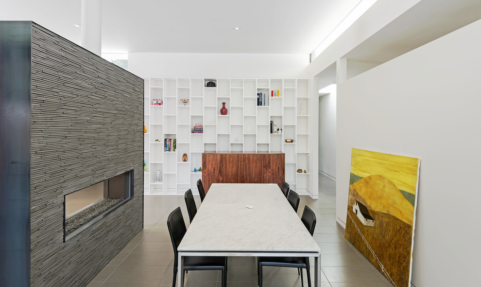 Ispirazione per una grande sala da pranzo aperta verso il soggiorno minimalista con cornice del camino piastrellata e camino bifacciale
