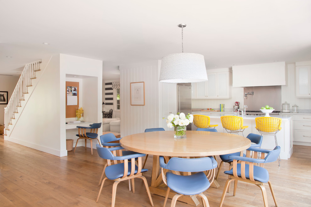 Cette photo montre une salle à manger ouverte sur la cuisine bord de mer de taille moyenne avec un mur blanc et un sol en bois brun.