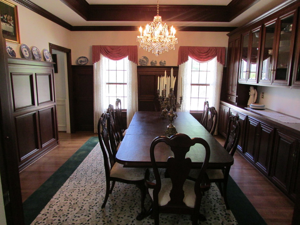 Foto di una sala da pranzo aperta verso il soggiorno tradizionale di medie dimensioni con pareti bianche, pavimento in legno massello medio e nessun camino