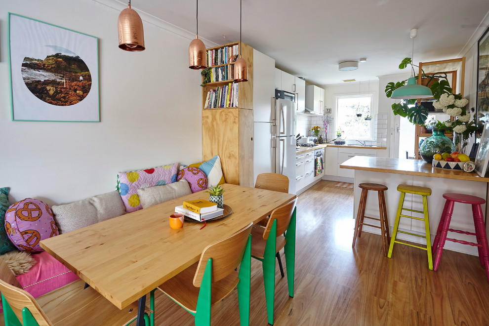 Idee per una sala da pranzo aperta verso il soggiorno boho chic con pavimento in legno massello medio