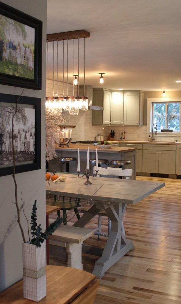 Small rural kitchen/dining room in Boston with grey walls, medium hardwood flooring, a two-sided fireplace, a plastered fireplace surround and brown floors.