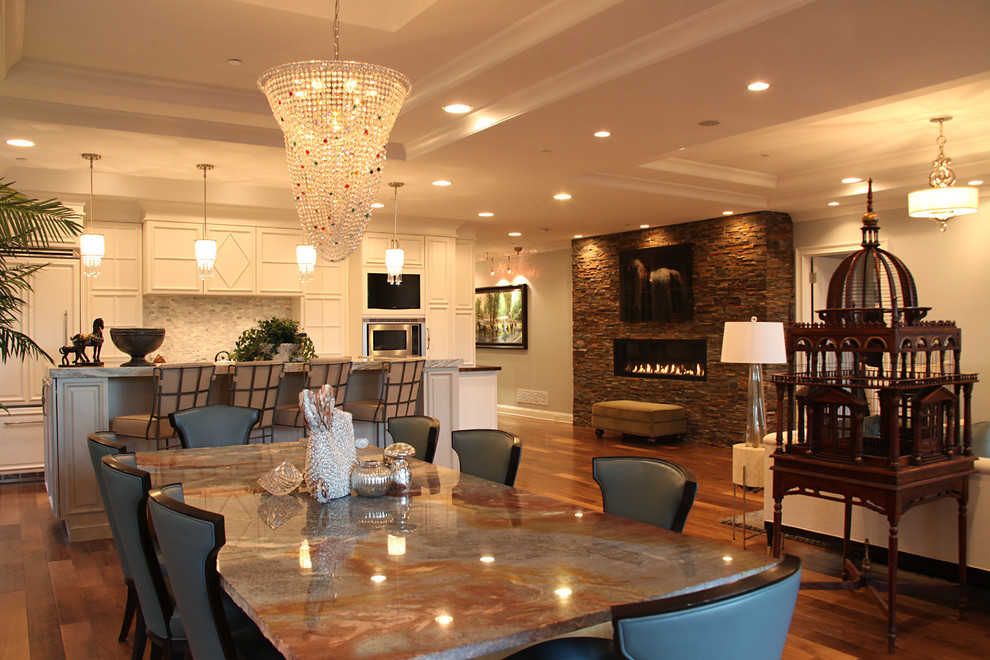 This is an example of a large modern open plan dining room in Boston with white walls, medium hardwood flooring, a standard fireplace, a stone fireplace surround and feature lighting.