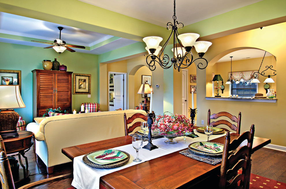 Immagine di una sala da pranzo aperta verso il soggiorno tradizionale di medie dimensioni con pareti verdi, parquet scuro e nessun camino