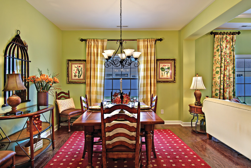 Foto di una sala da pranzo aperta verso il soggiorno classica di medie dimensioni con pareti verdi, parquet scuro e nessun camino