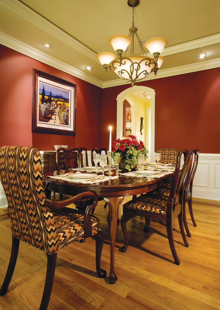 Foto di una grande sala da pranzo stile marinaro chiusa con pareti rosse, pavimento in legno massello medio e nessun camino