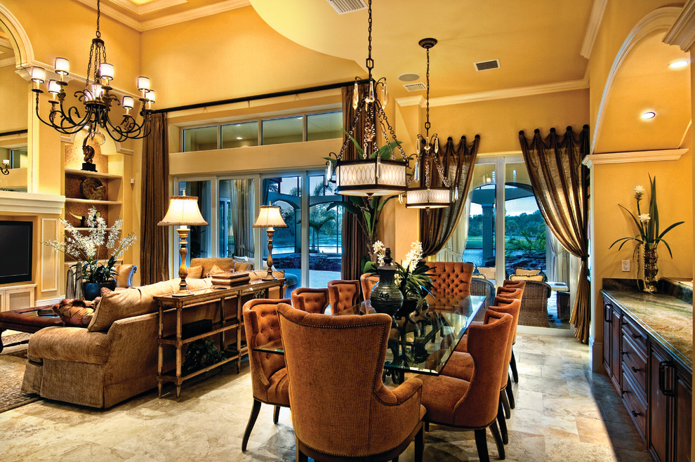 На фото: большая гостиная-столовая в средиземноморском стиле с желтыми стенами и полом из травертина без камина с