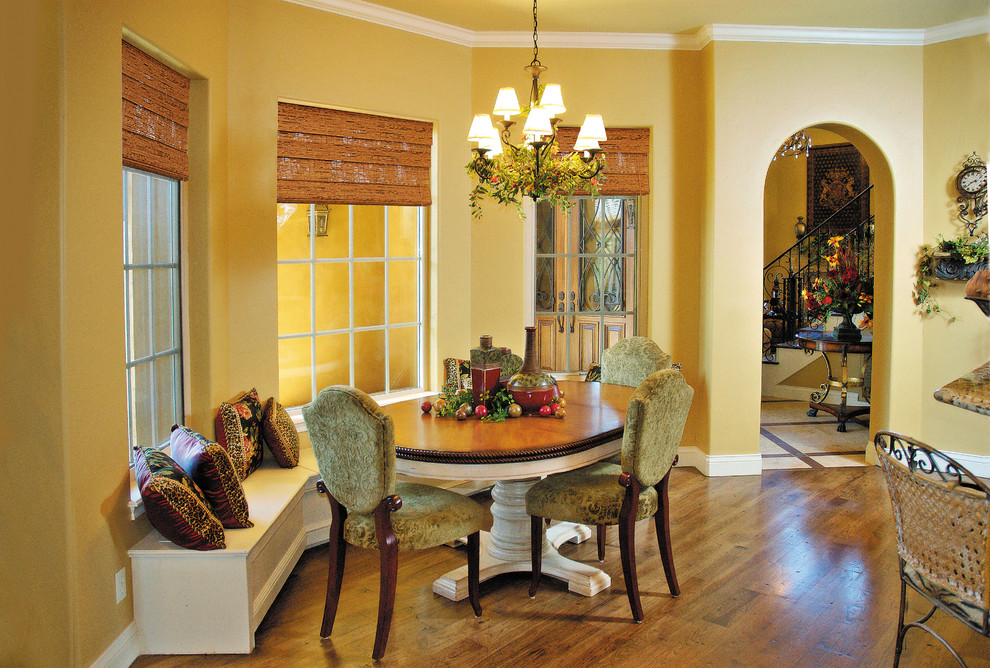 Esempio di una sala da pranzo aperta verso la cucina mediterranea di medie dimensioni con pareti gialle, pavimento in legno massello medio e nessun camino