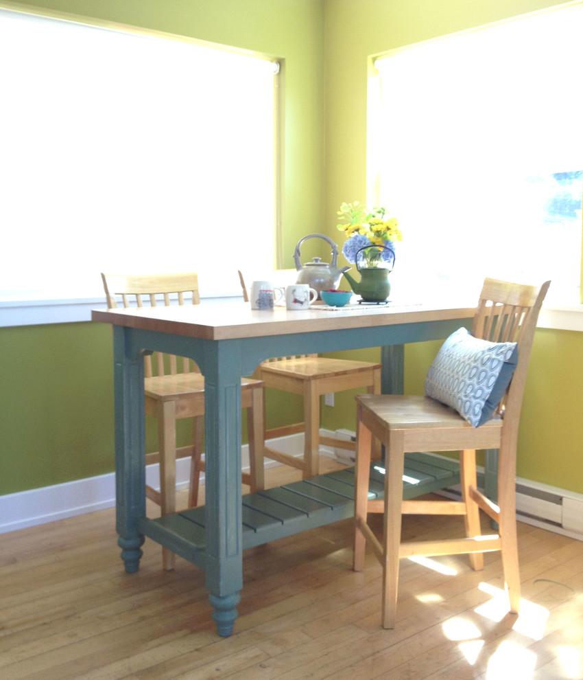 Immagine di una sala da pranzo aperta verso la cucina contemporanea di medie dimensioni con pareti verdi e parquet chiaro