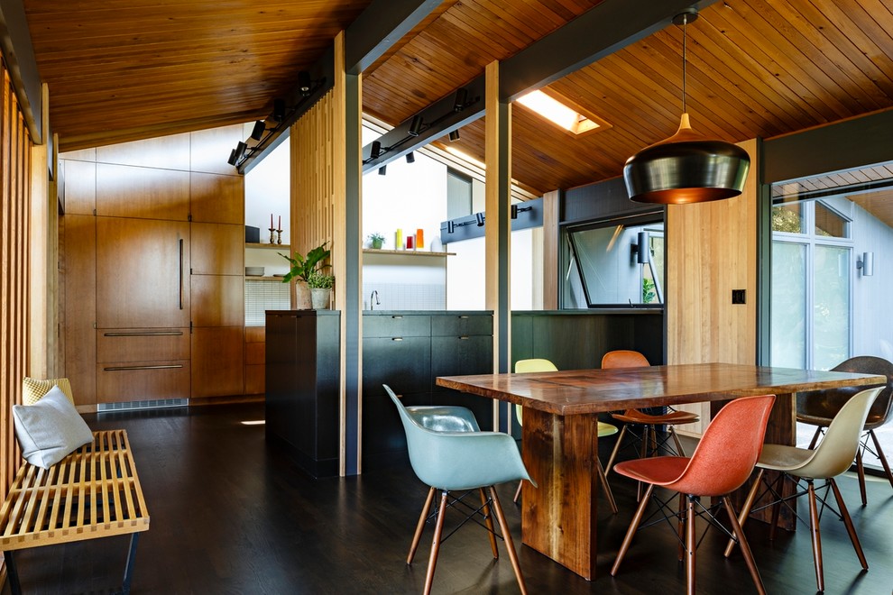 Cette photo montre une salle à manger ouverte sur le salon rétro avec parquet foncé et un sol marron.