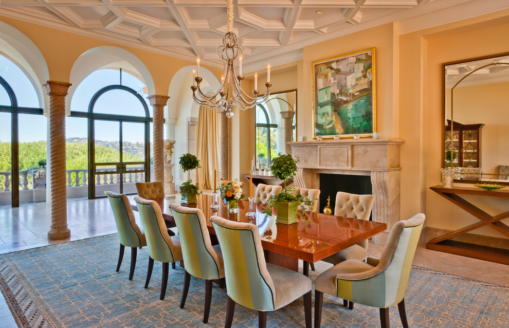 Photo of an expansive traditional enclosed dining room in San Francisco with yellow walls, marble flooring, a standard fireplace, a stone fireplace surround and brown floors.