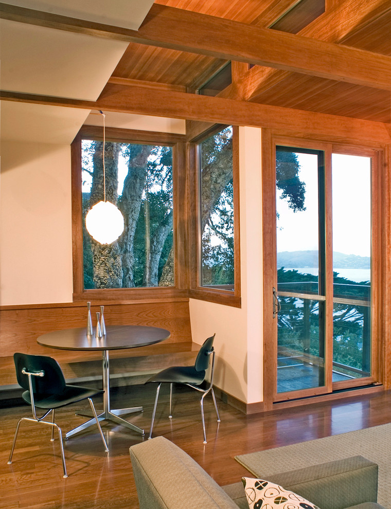 Exemple d'une salle à manger moderne avec un mur blanc, aucune cheminée et un sol en bois brun.