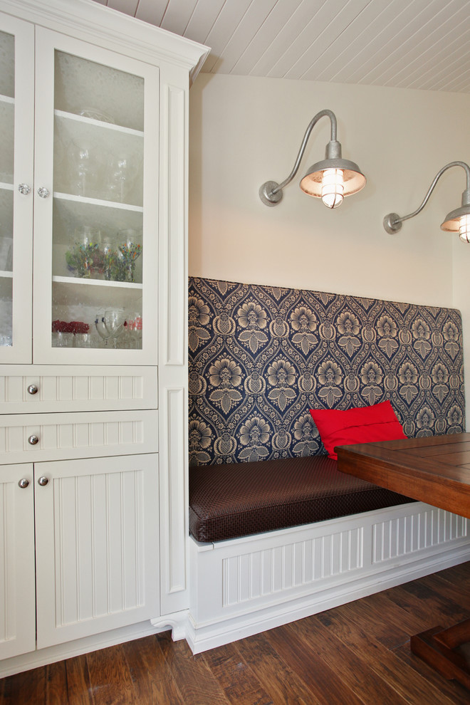 Réalisation d'une salle à manger tradition avec un mur blanc et parquet foncé.