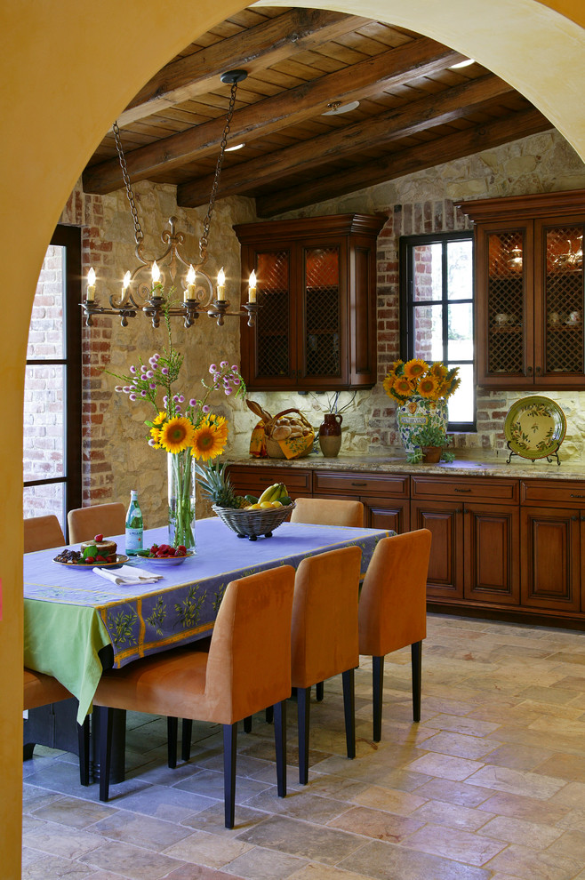 Пример оригинального дизайна: кухня-столовая среднего размера в средиземноморском стиле с бежевыми стенами, полом из известняка и бежевым полом без камина