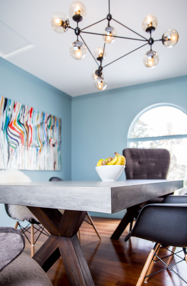 Esempio di una sala da pranzo nordica chiusa e di medie dimensioni con pareti blu, pavimento in legno massello medio, camino classico e cornice del camino piastrellata