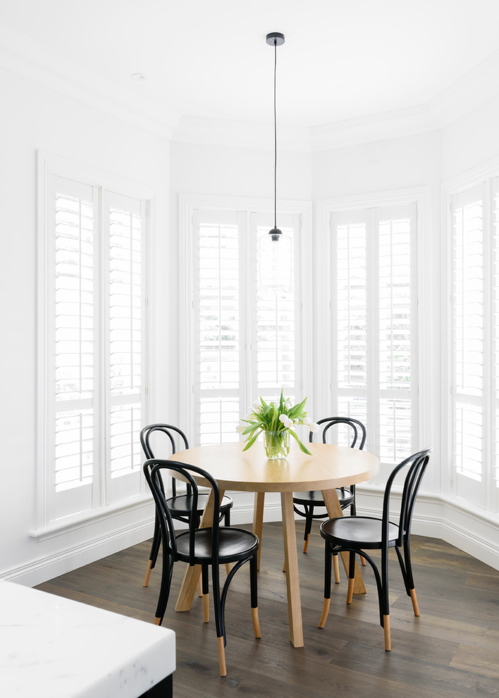 Ispirazione per una piccola sala da pranzo aperta verso la cucina scandinava con pareti bianche e pavimento in legno massello medio