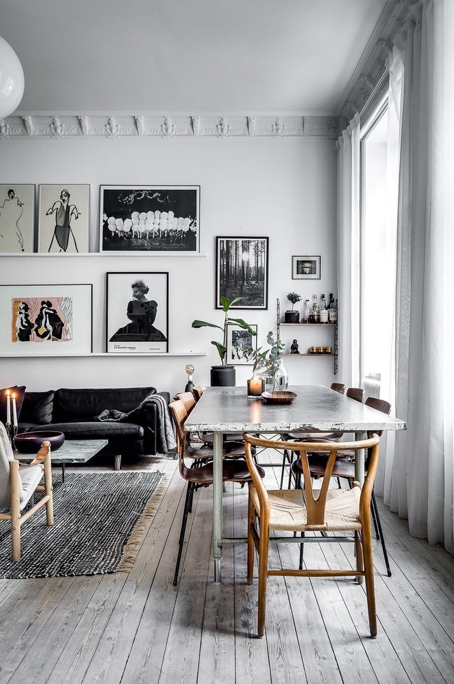 На фото: гостиная-столовая в скандинавском стиле с белыми стенами, светлым паркетным полом и серым полом