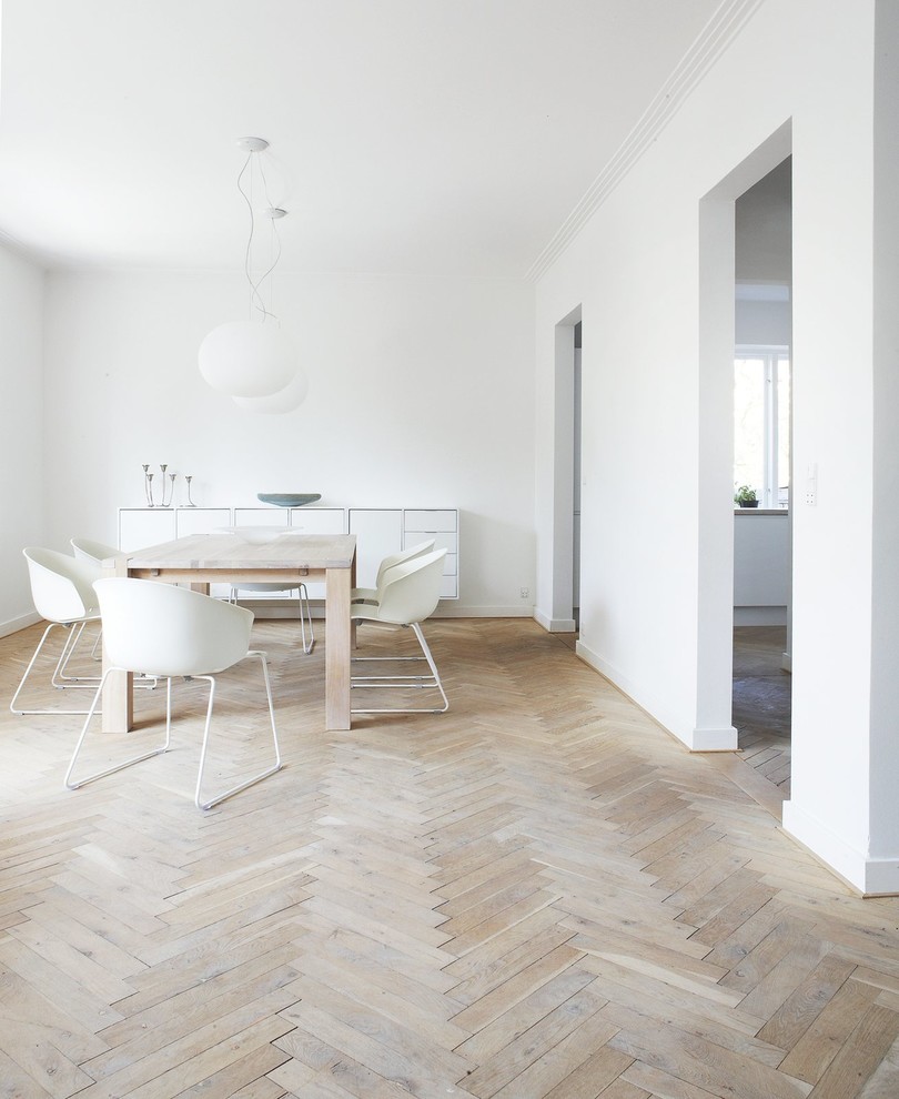This is an example of a medium sized scandi enclosed dining room in London with white walls, light hardwood flooring and no fireplace.