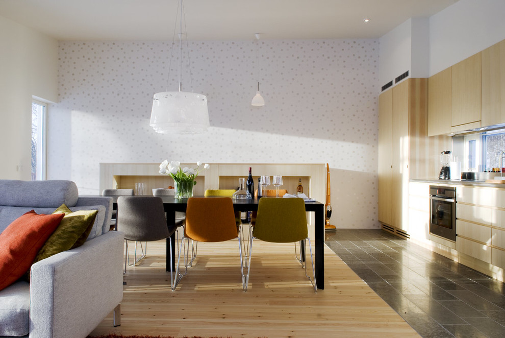Réalisation d'une salle à manger ouverte sur le salon nordique avec mur métallisé et parquet clair.