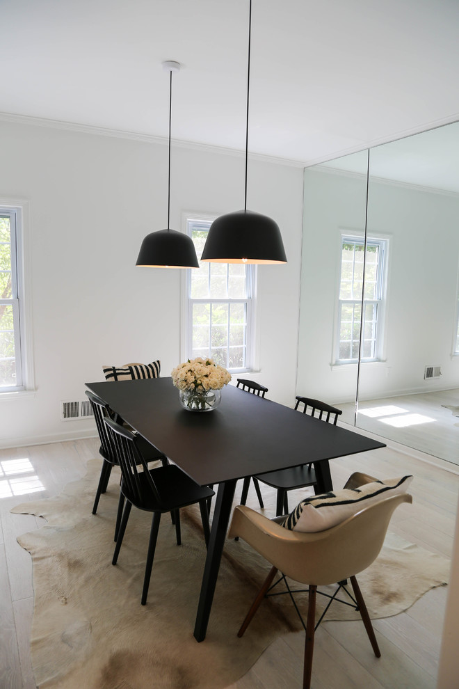 Foto di una sala da pranzo aperta verso la cucina minimalista di medie dimensioni con pareti bianche e parquet chiaro
