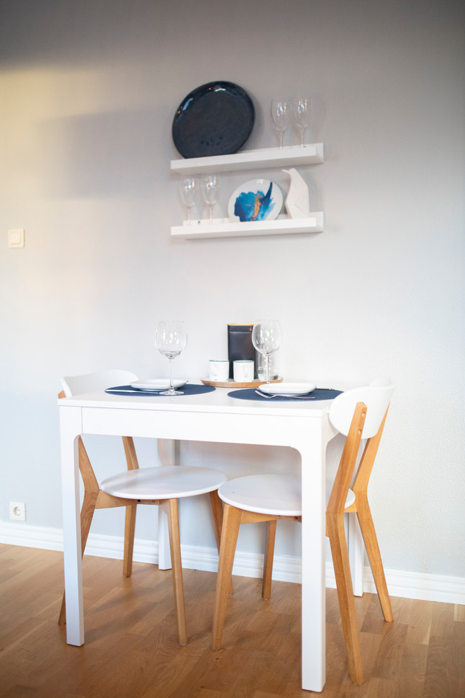 Inredning av en minimalistisk liten matplats med öppen planlösning, med grå väggar, ljust trägolv och gult golv