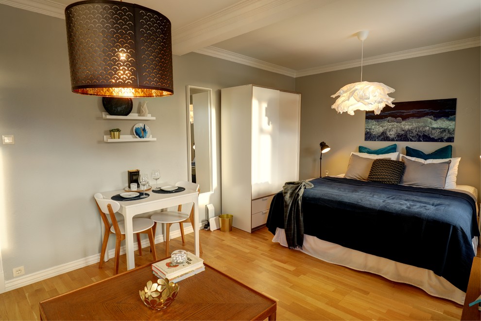 На фото: маленькая гостиная-столовая в скандинавском стиле с серыми стенами, светлым паркетным полом и желтым полом для на участке и в саду с