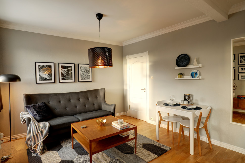 Пример оригинального дизайна: маленькая гостиная-столовая в скандинавском стиле с серыми стенами, светлым паркетным полом и желтым полом для на участке и в саду