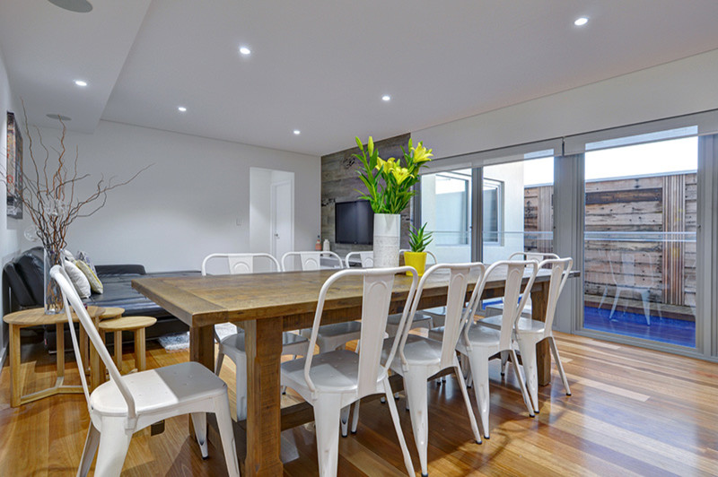 Idee per una sala da pranzo aperta verso la cucina design di medie dimensioni con pareti bianche e pavimento in legno massello medio