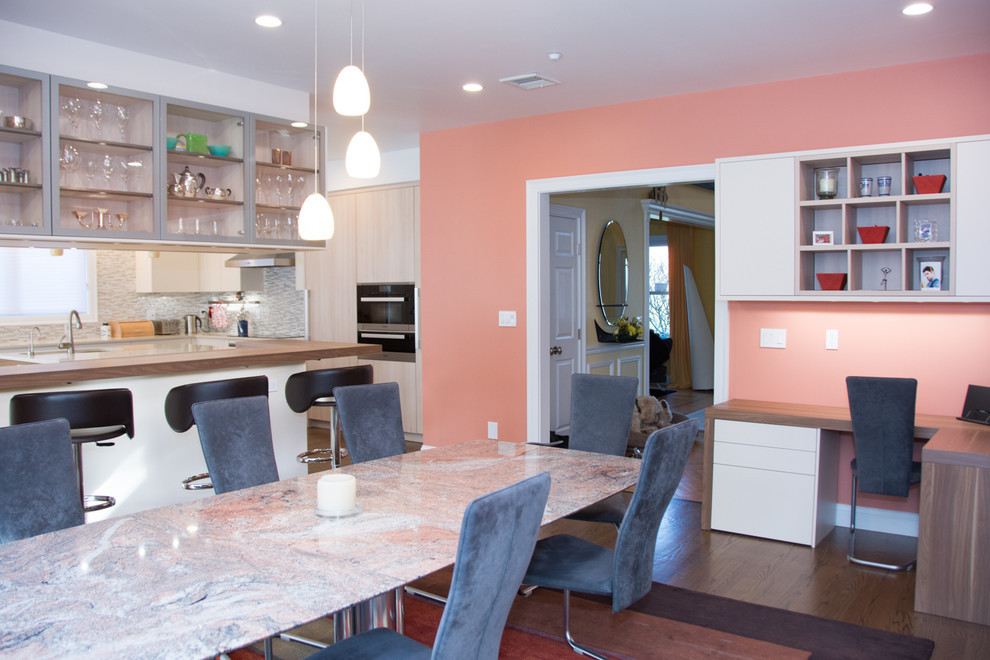 Immagine di una sala da pranzo aperta verso la cucina moderna di medie dimensioni con pareti rosa, parquet scuro e nessun camino