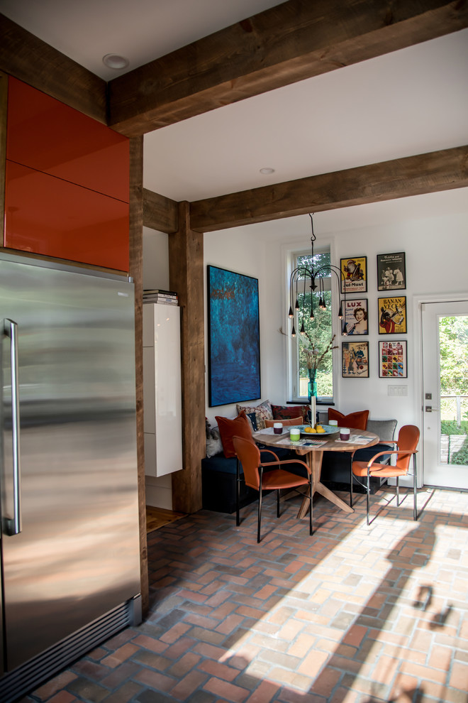 Cette image montre une salle à manger ouverte sur la cuisine rustique de taille moyenne avec un sol en brique et un sol rouge.