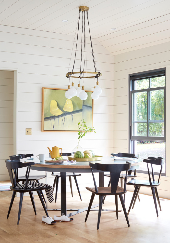 This is an example of a rural dining room in Portland with white walls and light hardwood flooring.