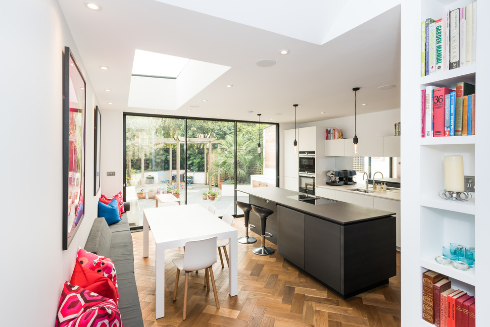 Idee per una sala da pranzo aperta verso il soggiorno minimal di medie dimensioni con parquet chiaro e pavimento beige
