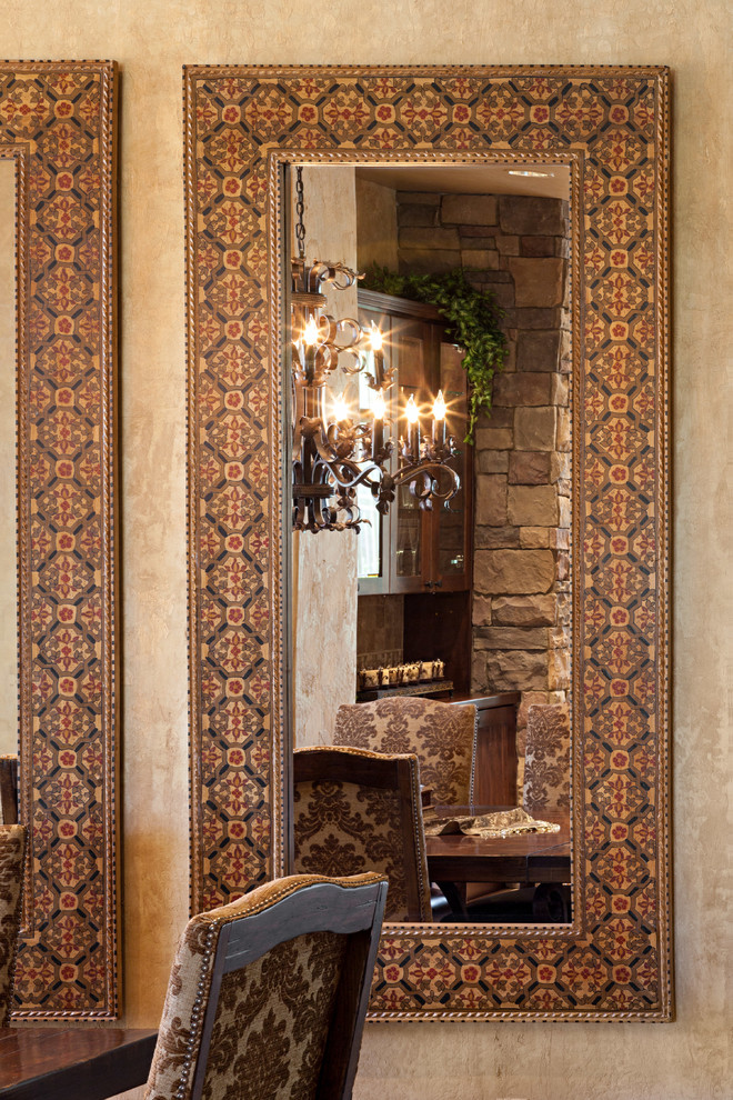 Foto di una sala da pranzo aperta verso il soggiorno mediterranea di medie dimensioni con pareti beige, pavimento con piastrelle in ceramica, camino classico e cornice del camino in pietra