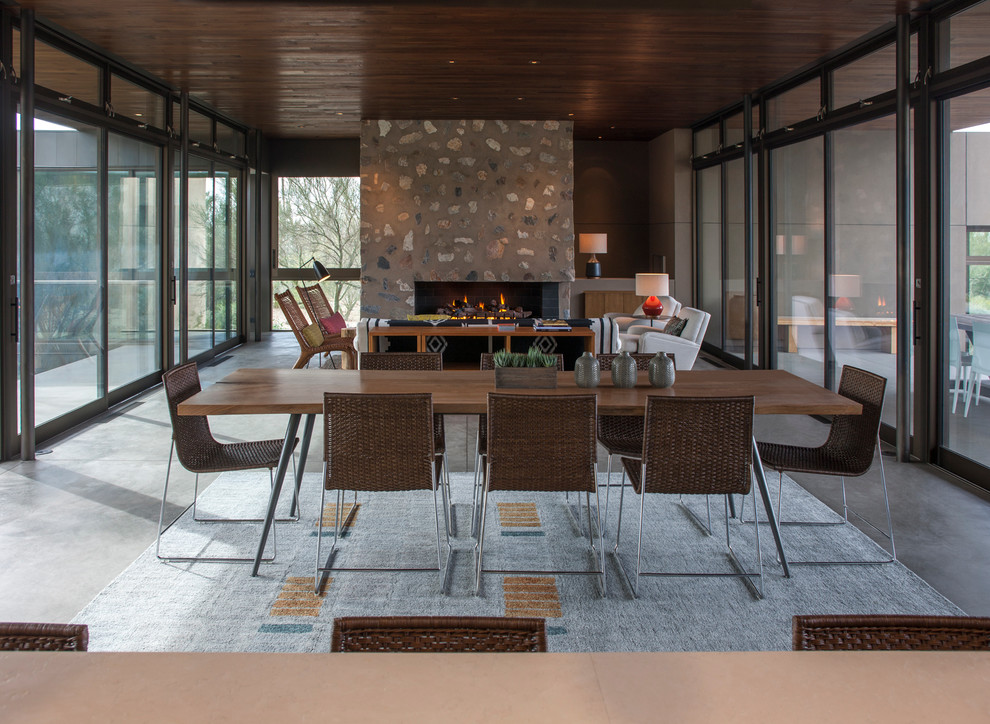 Aménagement d'une salle à manger ouverte sur le salon moderne avec sol en béton ciré.