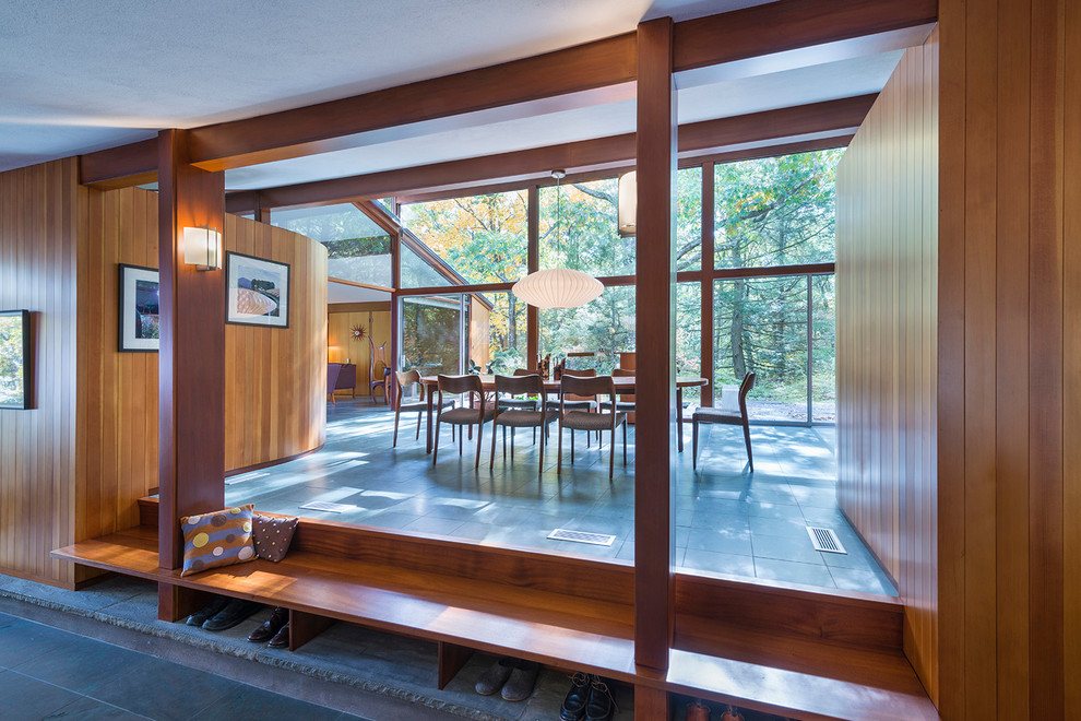 Esempio di una grande sala da pranzo aperta verso il soggiorno moderna con pavimento in ardesia e pareti marroni