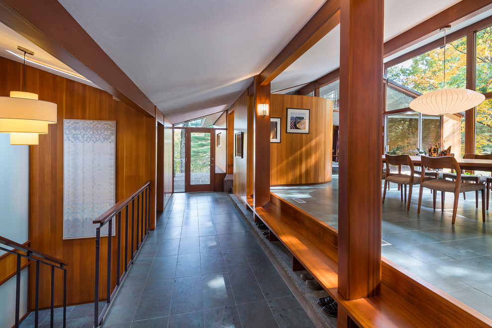Idee per una grande sala da pranzo aperta verso il soggiorno minimalista con pavimento in ardesia e pareti marroni