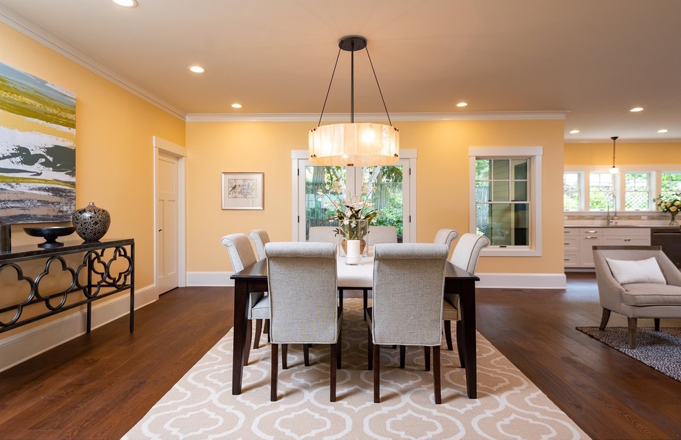 Inspiration for an open plan dining room in Portland with yellow walls, dark hardwood flooring and brown floors.