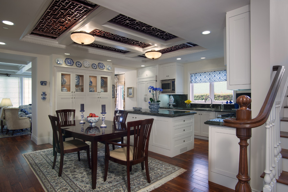 Immagine di una sala da pranzo aperta verso la cucina classica con pareti beige e parquet scuro