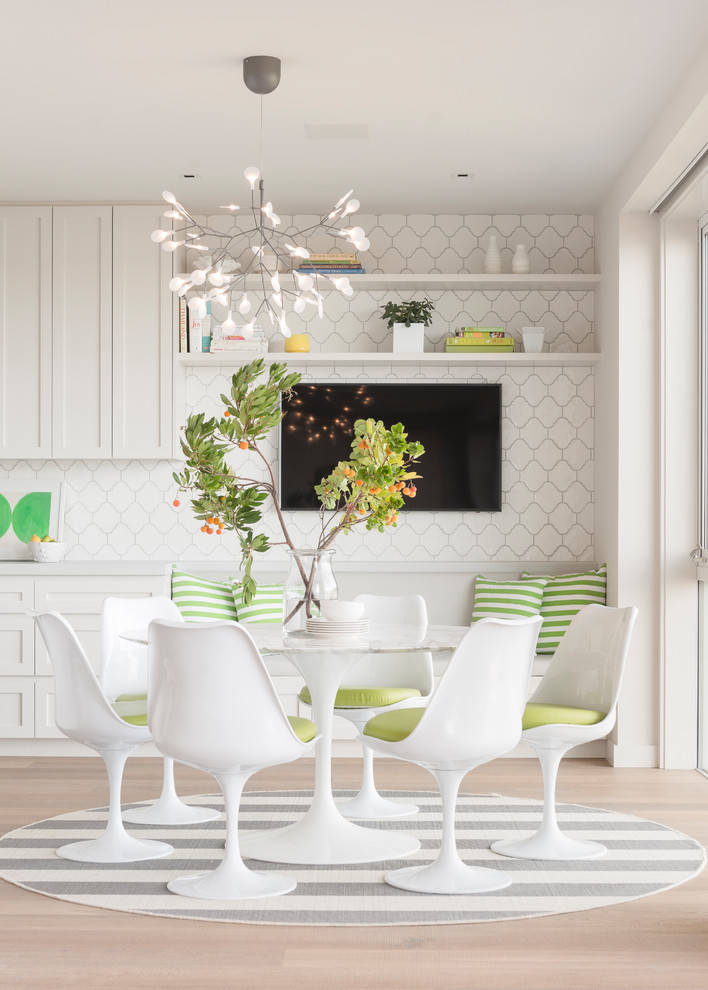 Idée de décoration pour une grande salle à manger ouverte sur la cuisine design avec un mur blanc, parquet clair et éclairage.