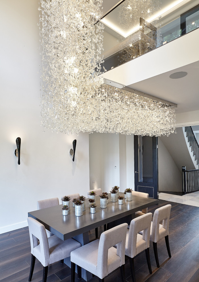 Modernes Esszimmer mit weißer Wandfarbe, dunklem Holzboden und braunem Boden in London